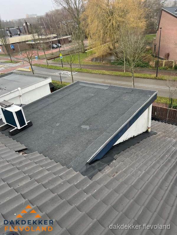 Plat dak met bitumen dakbedekking naast schuin pannendak in Flevoland Plat dak met bitumen dakbedekking naast schuin pannendak in Flevoland