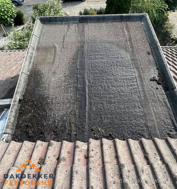 Verouderd plat dak met bitumen en slijtage voor lekkage inspectie in Flevoland Verouderd plat dak met bitumen en slijtage voor lekkage inspectie in Flevoland