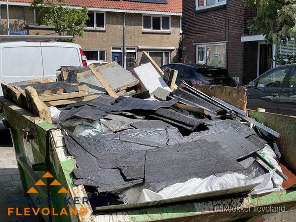 Afvalcontainer met gesloopt dakmateriaal tijdens dakkapel renovatie in Flevoland Afvalcontainer met gesloopt dakmateriaal tijdens dakkapel renovatie in Flevoland