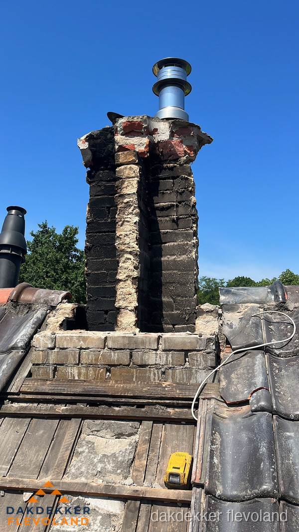 Beschadigde schoorsteen met nieuwe rookgasafvoer op oud dak in Flevoland Beschadigde schoorsteen met nieuwe rookgasafvoer op oud dak in Flevoland