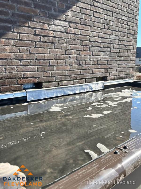 Stilstaand water op plat dak door slechte afwatering in Flevoland