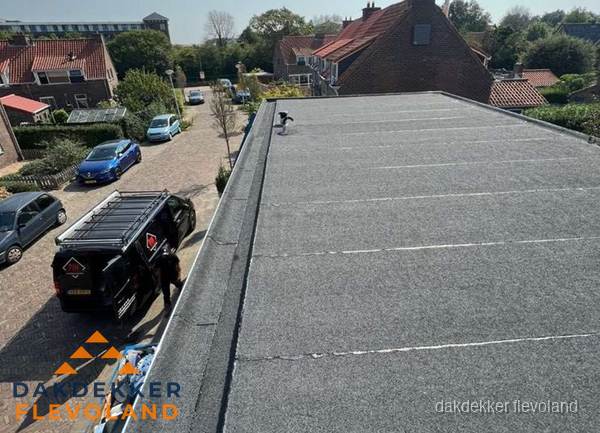 Nieuw bitumen plat dak met uitzicht over woonwijk in Flevoland