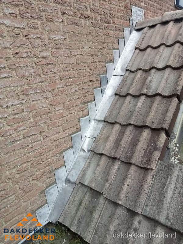 Loodslabben langs dakaansluiting bij bakstenen muur in Flevoland Loodslabben langs dakaansluiting bij bakstenen muur in Flevoland