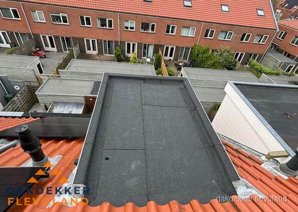 Plat dak met bitumen bedekking naast dakkapel in Flevoland Plat dak met bitumen bedekking naast dakkapel in Flevoland