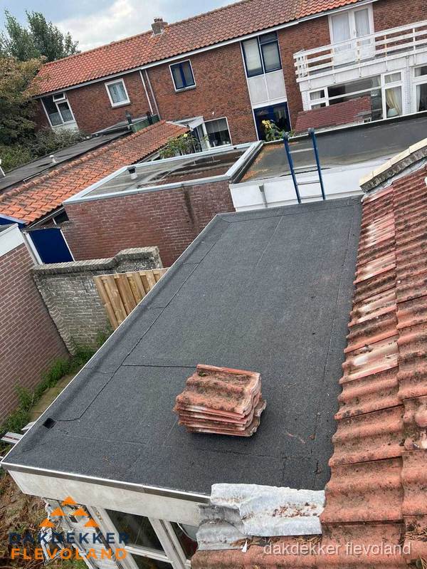 Plat dak aanbouw met bitumen naast schuin pannendak in Flevoland Plat dak aanbouw met bitumen naast schuin pannendak in Flevoland