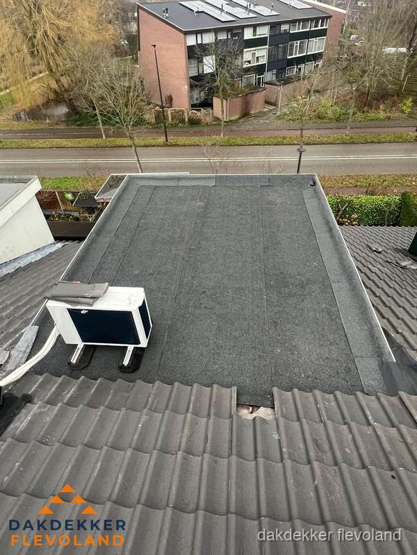 Plat dak inspectie met bitumen bedekking naast schuin pannendak in Flevoland Plat dak inspectie met bitumen bedekking naast schuin pannendak in Flevoland