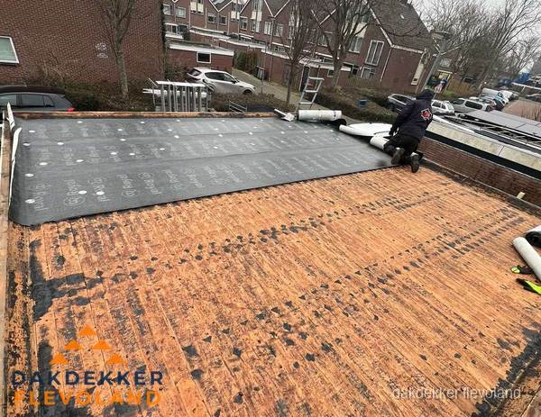 Dakdekker legt onderlaag op plat dak met houten constructie in Flevoland Dakdekker legt onderlaag op plat dak met houten constructie in Flevoland